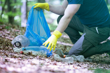 Volunteer collecting garbage in the woods.