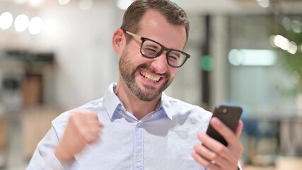 Portrait of Excited Businessman Cheering for Online Win