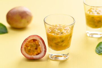 Fresh passion fruit juice in glass on yellow background, Tropical drink