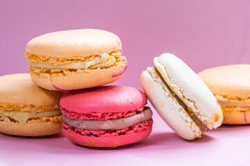 Colorful french cookies macarons set on pink background. Tasty fruit, almond sweet cookies, cake macaron. Holiday backdrop design.