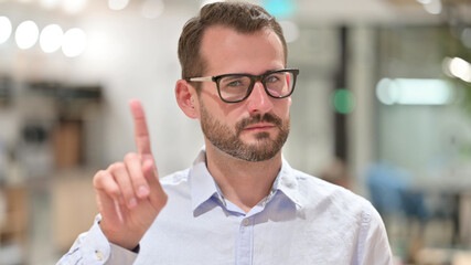 Portrait of Serious Businessman saying No by Finger Sign