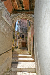 A street between old medieval stone buildings of Bassiano, historic town in Lazio region, Italy.