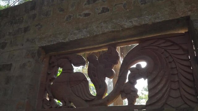 Sunlight striking and beaming through Ancient Indian architecture. Vintage Indian wall sculpture with sun shining behind them