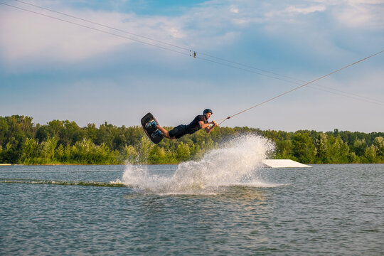 Man skilfully making tricks on wakeboard on summr day