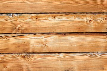 Wooden surface made of horizontal planed lumber. Cracks, woody patterns, knots.