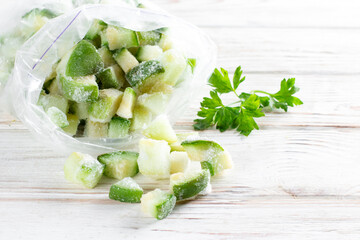 Frozen zucchini in a bag on white table. Frozen food. Copy space