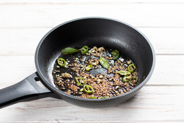 Fried spices in a pan. Ingredients for cooking Gobi Aloo cauliflower and potatoes, horizontal