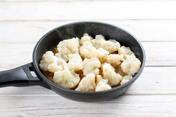 Fried cauliflower with spices in a pan. Ingredients for cooking Gobi Aloo cauliflower and potatoes, horizontal