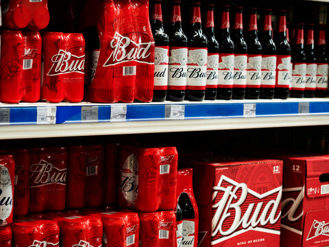 Cans and bottles of Bud beer on a shelf in a store