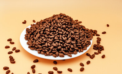 A bunch of chocolate rice on a yellow background, side view