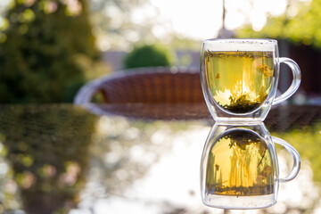 Cup with herbal tea on the table, gazebo in the backyard