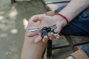 A young adult holds a bunch of keys in his hand.