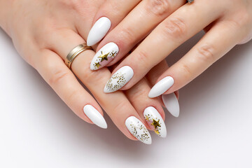 Festive nail design. White manicure on sharp long nails close-up on a white background with painted...
