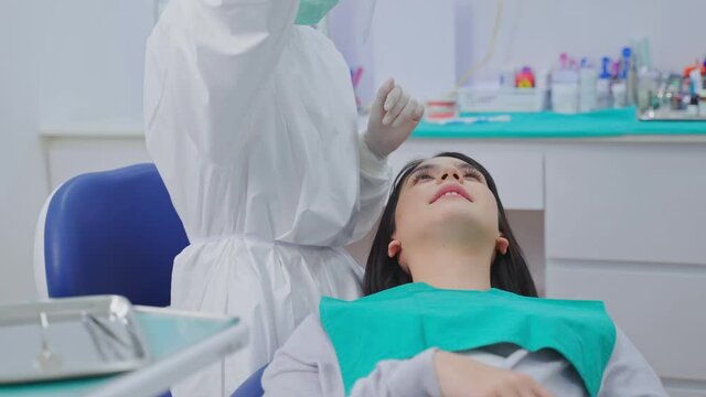 Caucasian female customer getting tooth checkup in dental clinic.