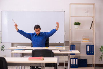 Young male teacher in front of whiteboard