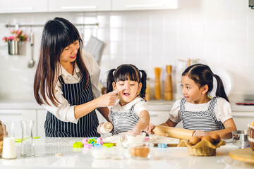 Portrait of enjoy happy love asian family mother and little toddler asian girl daughter child having fun cooking together with dough for homemade bake cookie and cake ingredient on table in kitchen