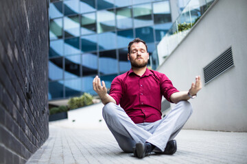 Businessman practicing yoga on sidewalk