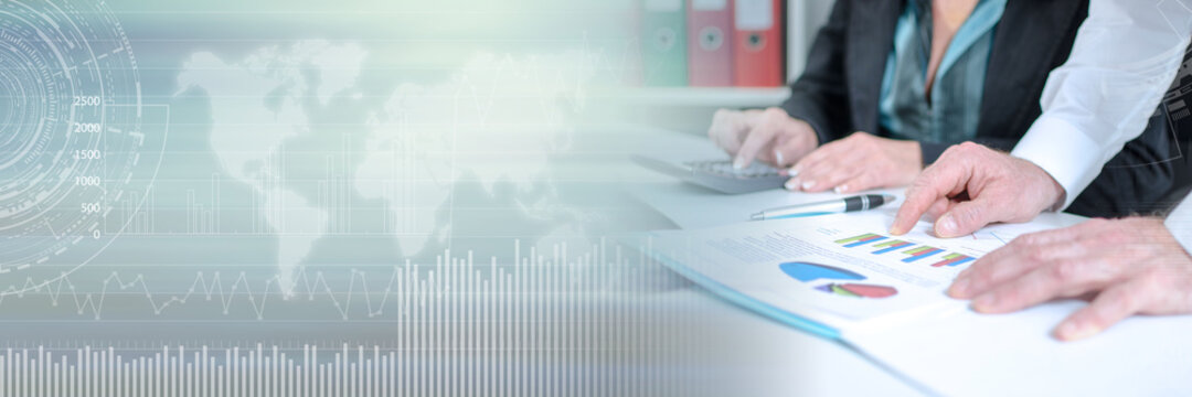 Workteam analyzing graphs and using a calculator; panoramic banner