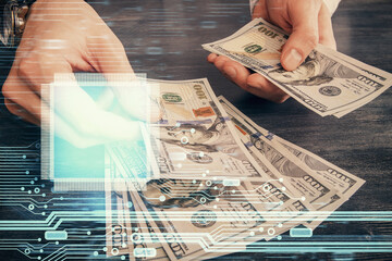 Multi exposure of technology drawing hologram and us dollars bills and man hands. Data concept