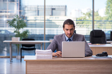 Fototapeta premium Young male employee working in the office