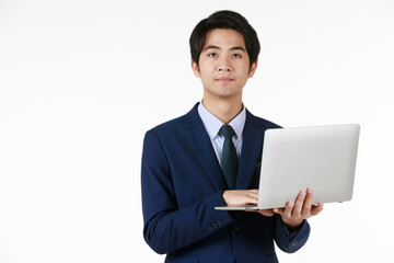 Young Asian businessman in a blue suit. Standing work in hand holding laptop. White background gives a formal feel, empty space can enter text.