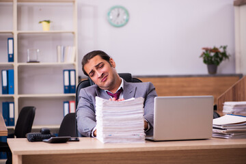 Young male employee extremely tired with excessive work