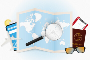 Travel destination Tajikistan, tourism mockup with travel equipment and world map with magnifying glass on a Tajikistan.