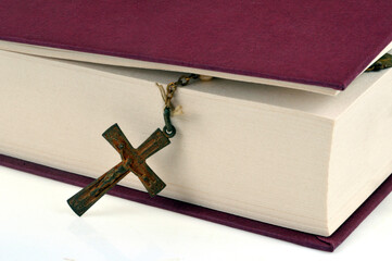 Crucifix sortant des pages d'une bible en gros plan - obrazy, fototapety, plakaty