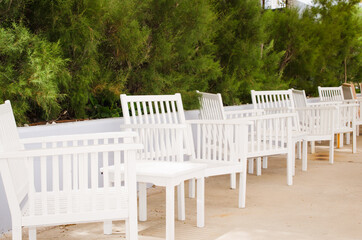 White tables and chairs on the terrace of a cozy summer cafe in Turgutreis town.