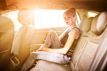 Dreaming woman sitting in car at sunset