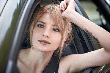 Fototapeta na wymiar Young woman leaning out of car window