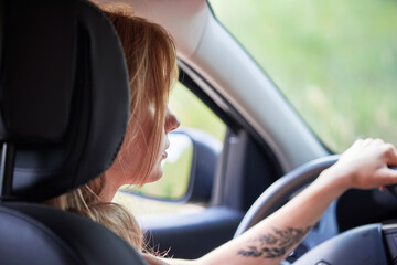 Fototapeta na wymiar Blond woman driving a car automobile interior hands on wheel