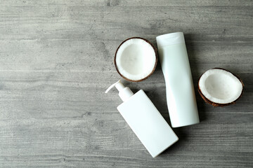 Shower gels and coconut on gray textured background