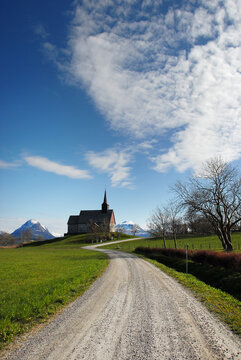 Ed&oslash;y Church, Sm&oslash;la, Norway. A road leading to the church. Tustna mountains in the background.