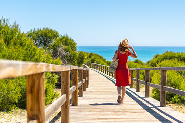 A young girl on the wooden path to Playa Moncayo in Guardamar del Segura next to Torrevieja,...