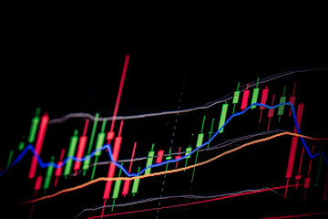 A stock market graph over the dark background. 