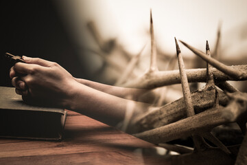 A prayer hand with thorn crown.