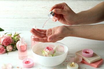 Female hands hold pipette with rose essential oil, close up