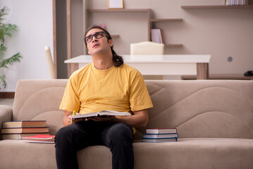 Young male student preparing for exams at home