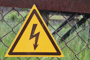 a sign of danger. Dark brown lightning against the yellow triangle