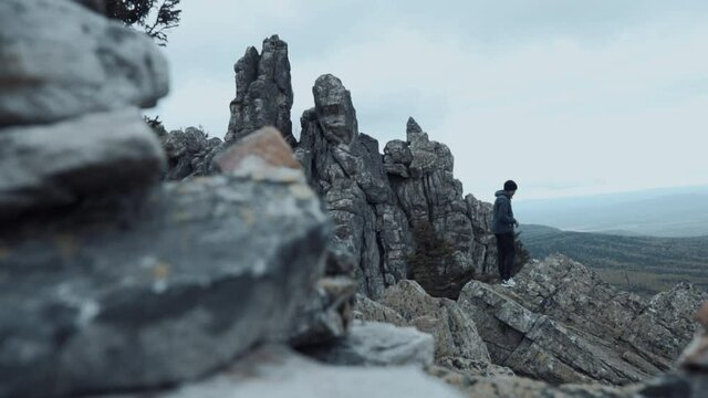 Hicker Standing On The Top Of The Cliff Looking Sideways Enjoying The Mountain Scenery. Travel Concept Active People on the Way to Victory Move Forward