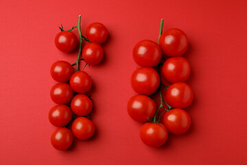 Fresh cherry tomato branches on red background