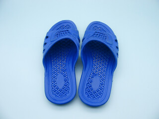 blue beach classic plastic flip-flops on a light blue background. Rear view.