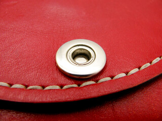 The rivet is metal and the seam is waxed thread on the red wallet. unopened.