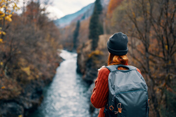 woman hiker backpack river travel to the mountains