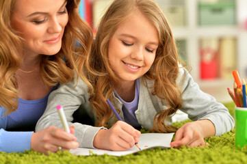 little cute girl with mother drawing