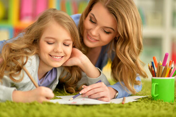 little cute girl with mother drawing
