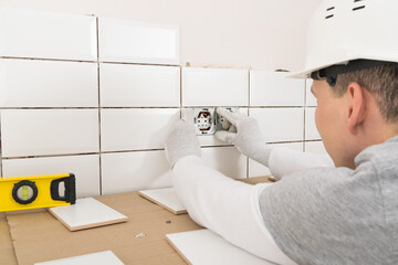 Obraz premium the master installs sockets in the wall in the kitchen, repair work in the apartment