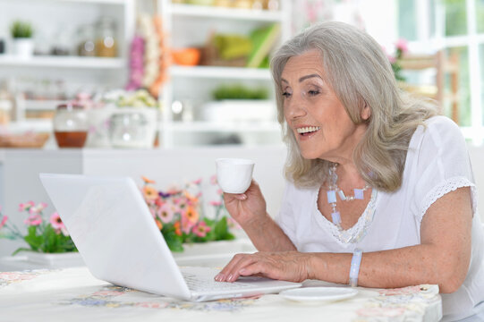 Happy senior woman using laptop
