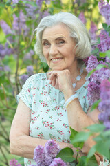 happy  senior beautiful woman on  lilacs background